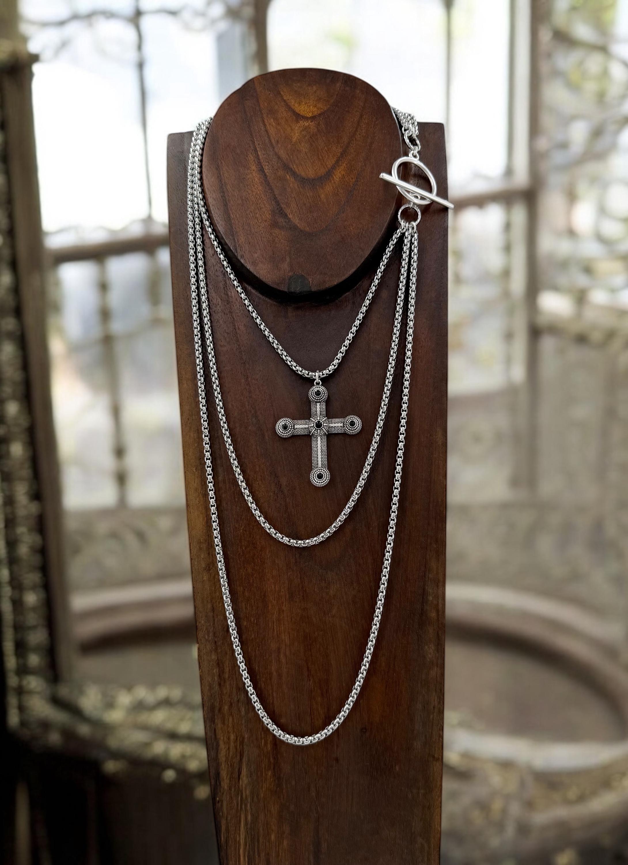 Long dark silver triple-chain necklace with black enamel cross pendant, bold layered choker