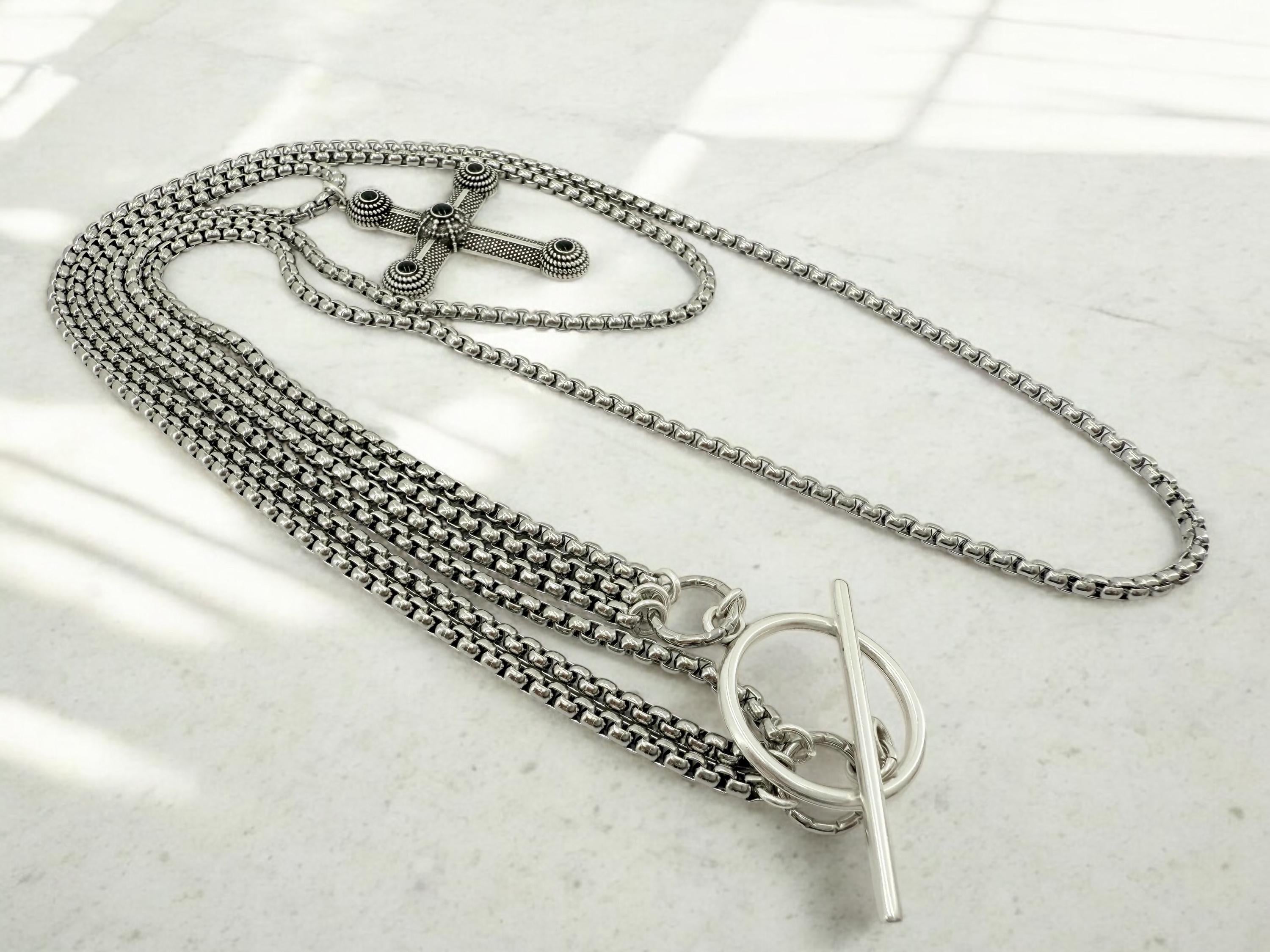 Long dark silver triple-chain necklace with black enamel cross pendant, bold layered choker