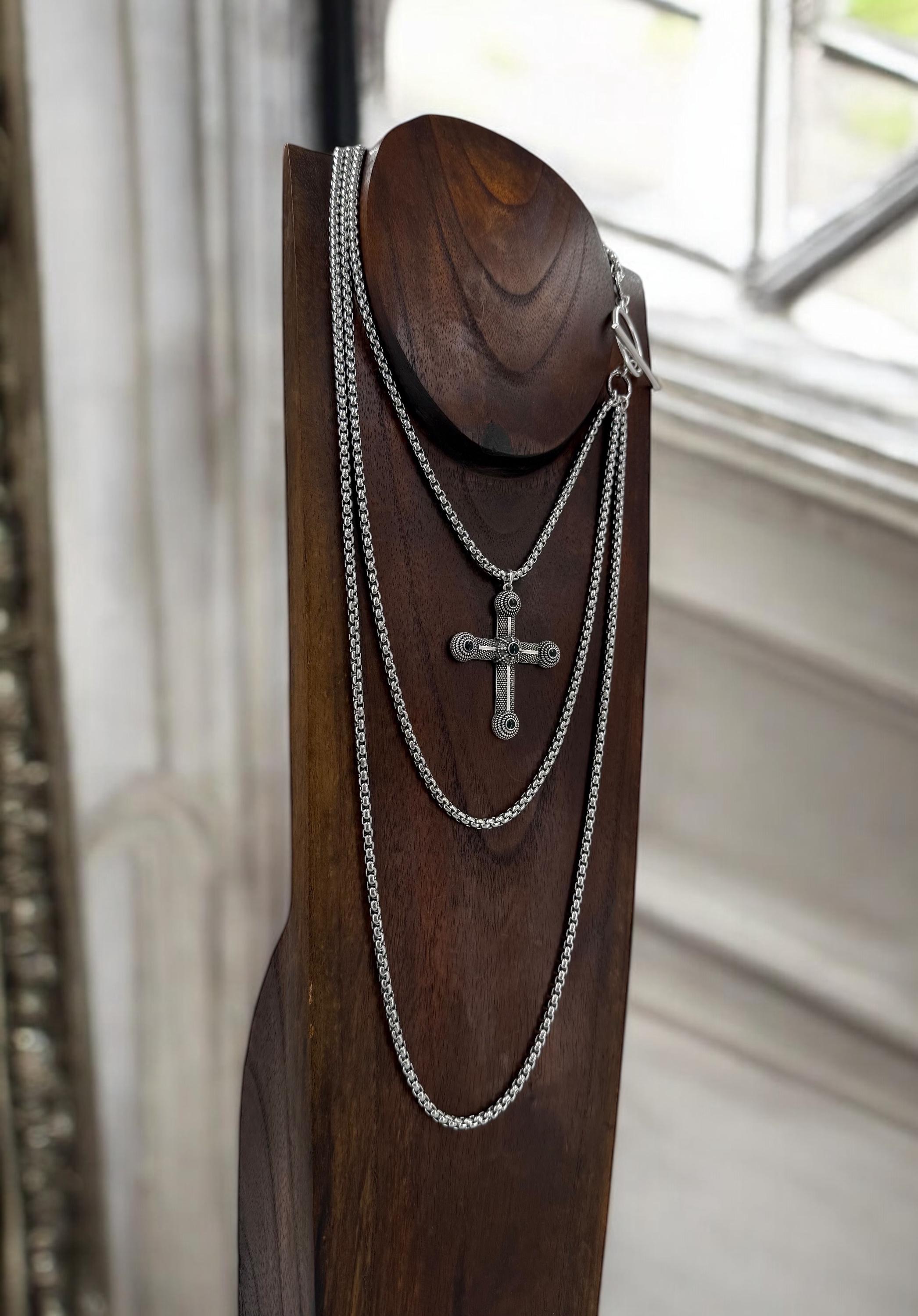 Long dark silver triple-chain necklace with black enamel cross pendant, bold layered choker