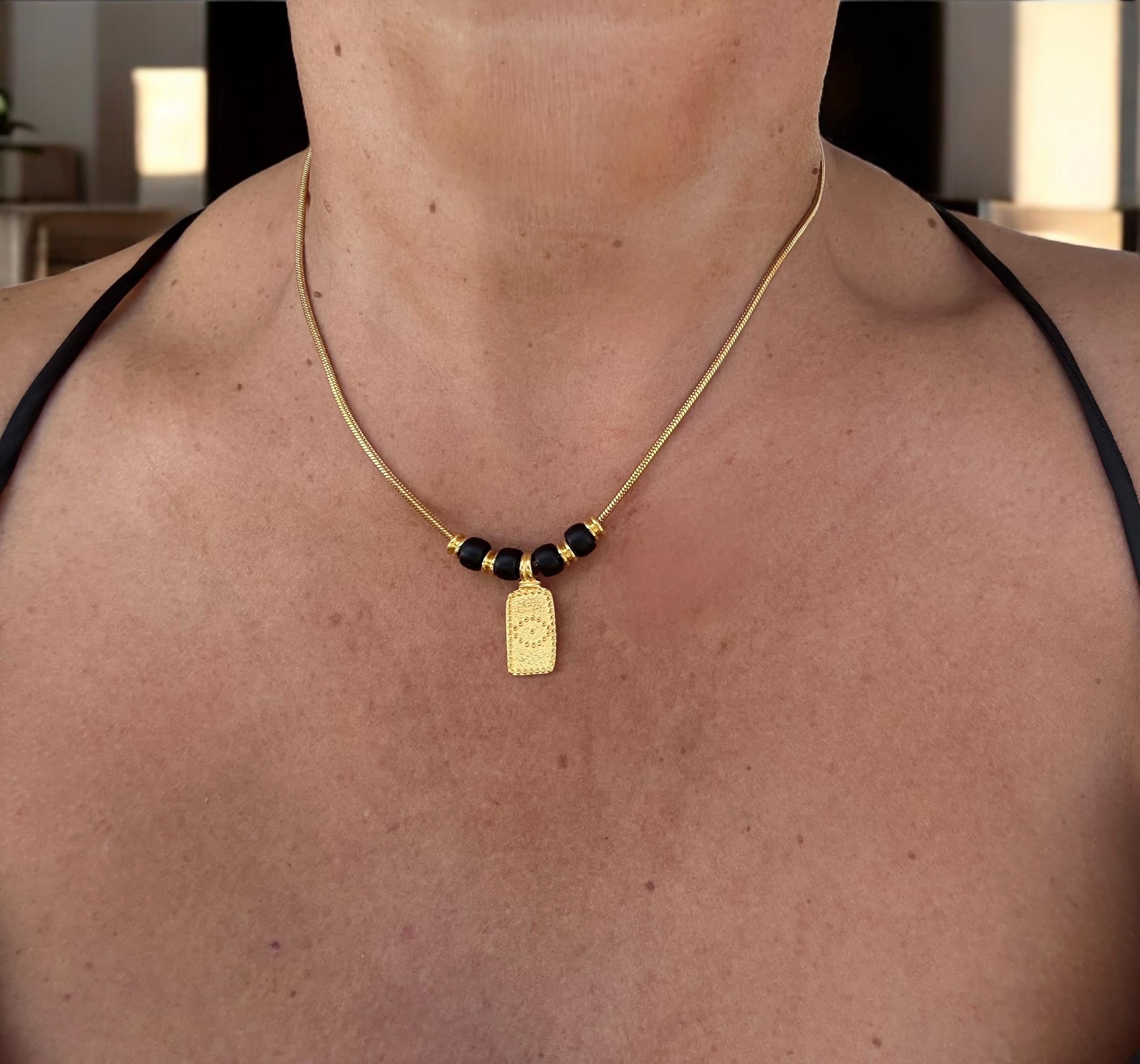 Dainty gold necklace with symbolic eye pendant and black crystals, delicate tribal choker