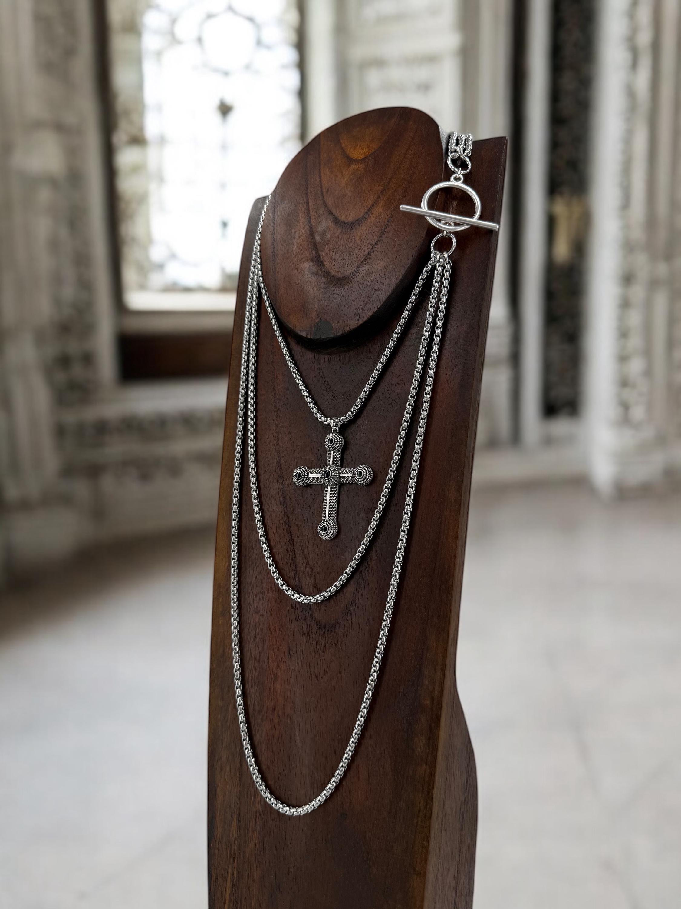 Long dark silver triple-chain necklace with black enamel cross pendant, bold layered choker