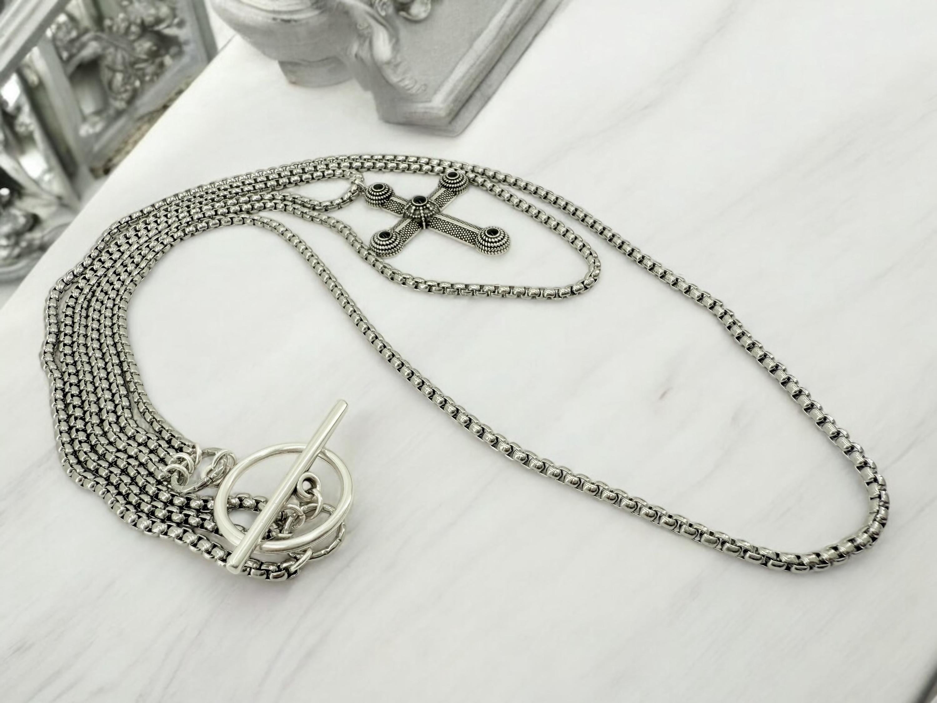 Long dark silver triple-chain necklace with black enamel cross pendant, bold layered choker