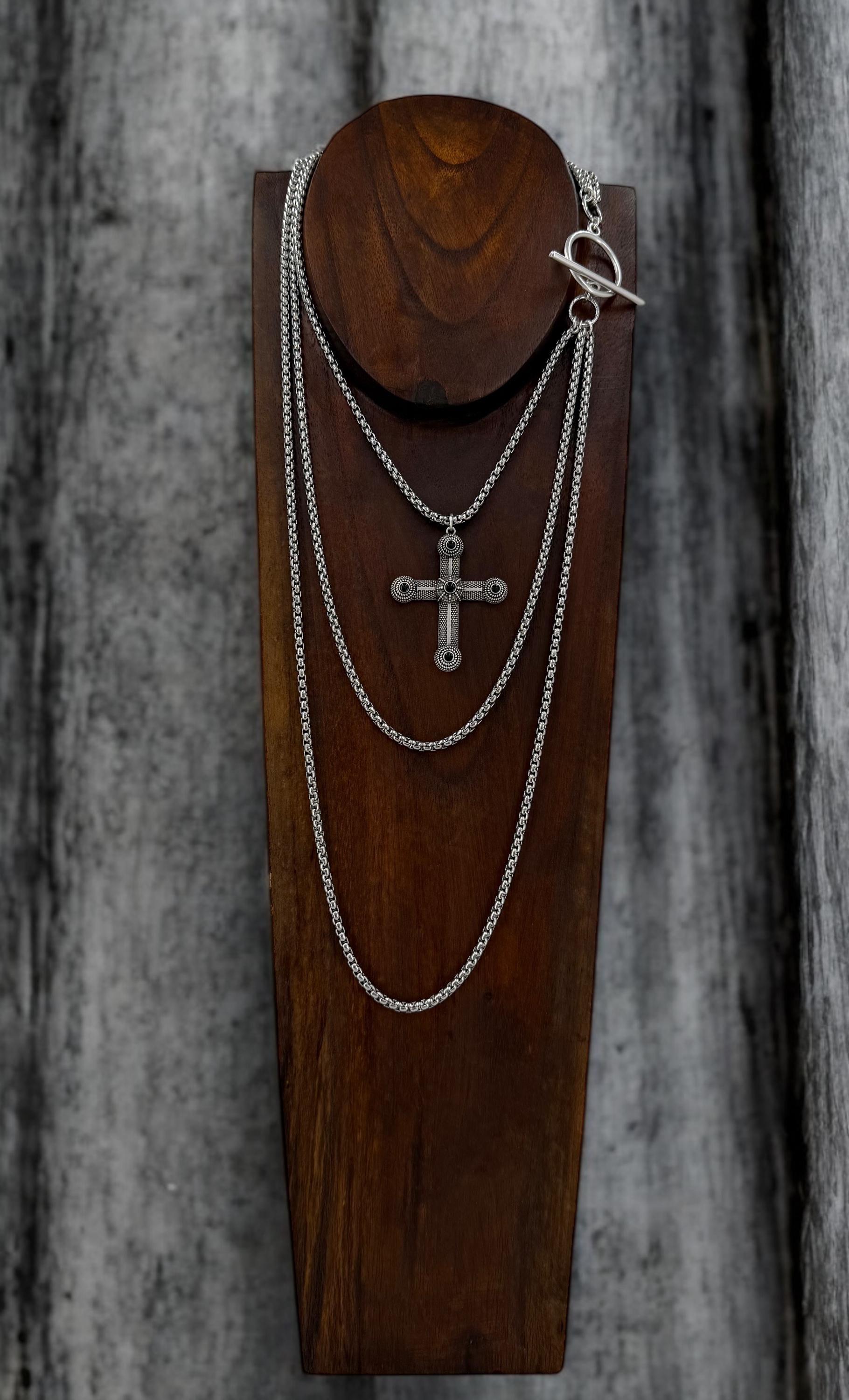 Long dark silver triple-chain necklace with black enamel cross pendant, bold layered choker