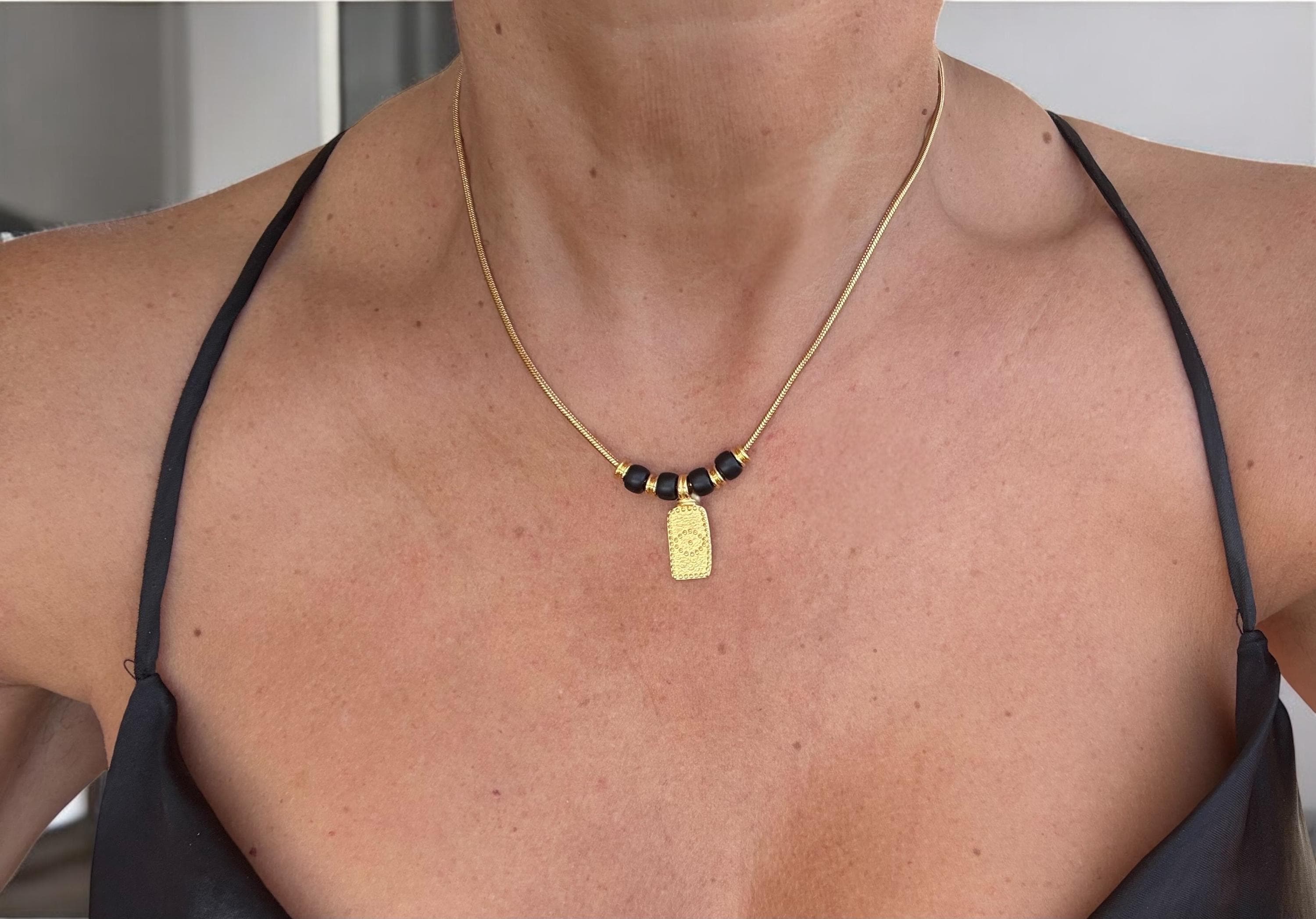 Dainty gold necklace with symbolic eye pendant and black crystals, delicate tribal choker